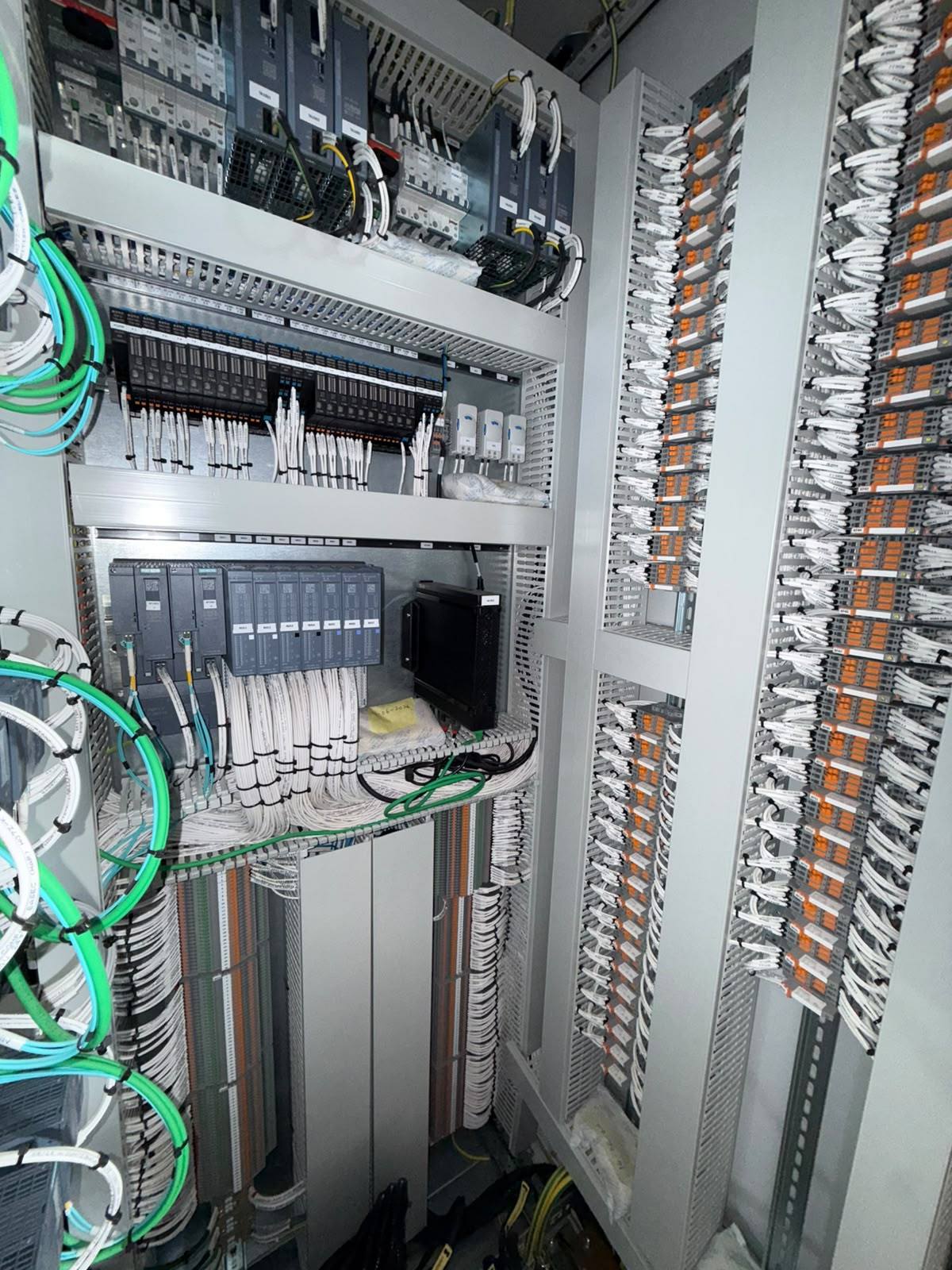 Control cabinet with distributed I/O and fibre links on the left and interface relay columns on the right