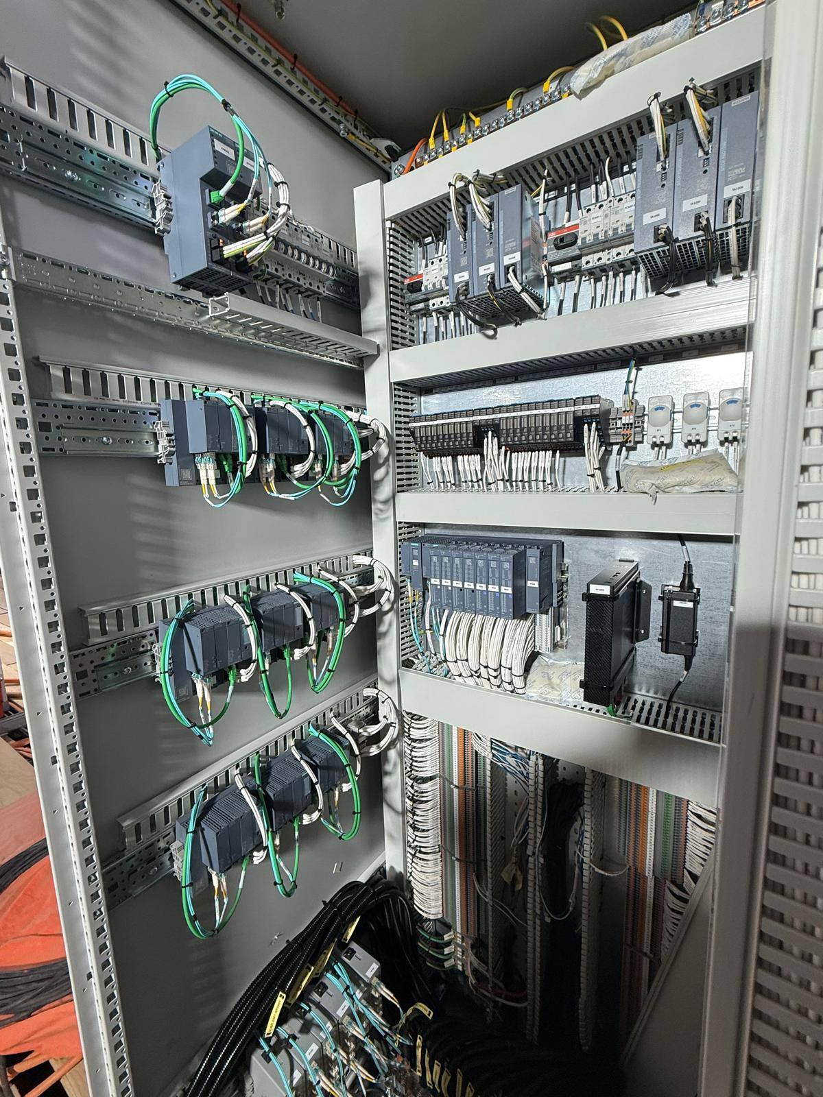 Open PLC control cabinet on an HVDC platform with network switches, power supplies, I/O and terminals
