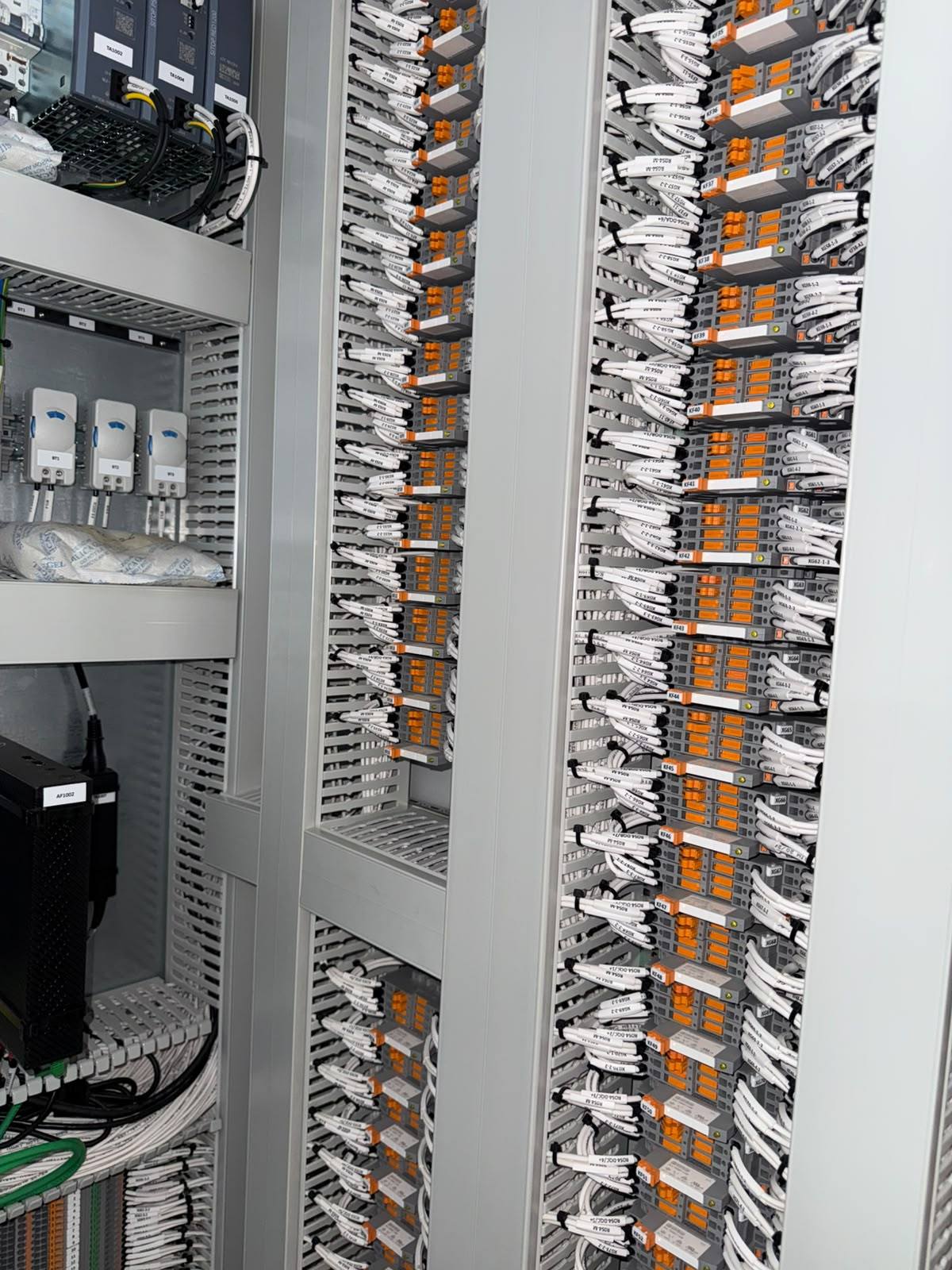 Close-up of labelled interface relays, cabinet thermostats and SITOP 24 V DC power supplies